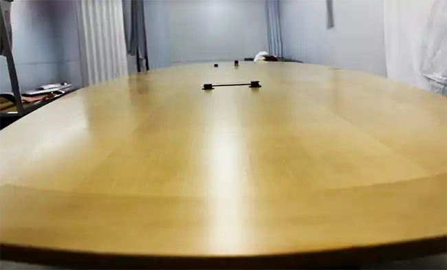 Close-up detail of the woodgrain finish on the rental conference table, showing craftsmanship