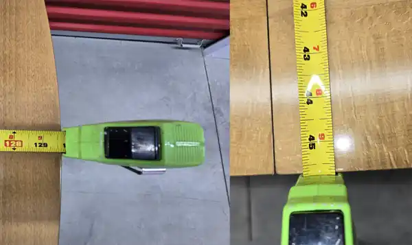Close-up of tape measure showing width and thickness of conference table