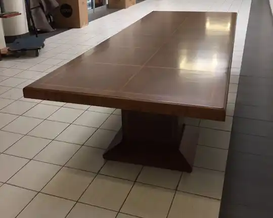 Angled front-side view of rectangular wood veneer conference table with panel base