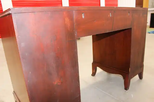 Rear view of desk showing finish wear and construction