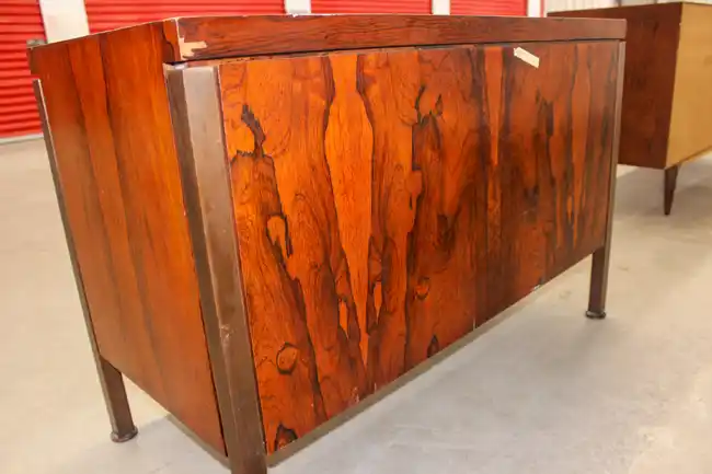 Angled view of rosewood credenza showing legs and door grain