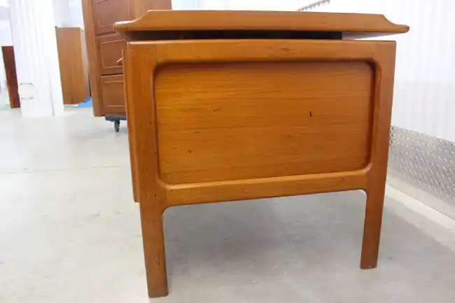 Rear panel of Scandinavian teak desk with sculpted legs
