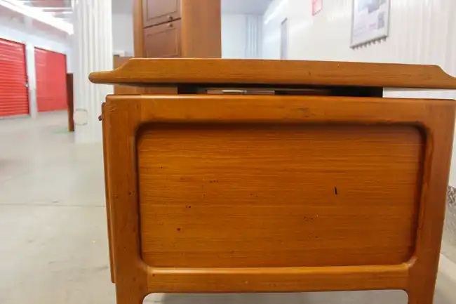 Side profile of teak desk showing floating top design
