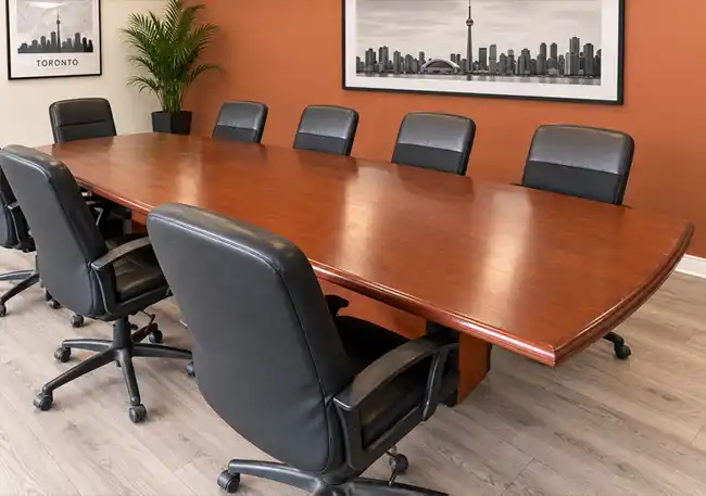 Long mahogany-colour boardroom table with boat-shaped top and dual drum base, ideal for corporate meetings or film rentals.